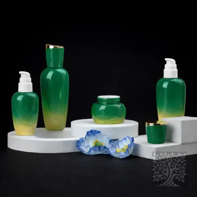 Green to yellow gradient glass skincare bottles and jars with gold caps, styled on white platforms with floral accents.