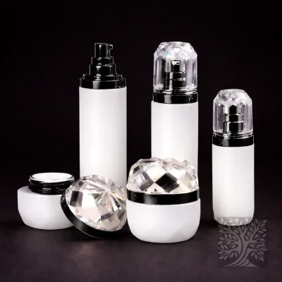 White faceted skincare bottles and cosmetic jars with black and gold accents, arranged in a clean high-contrast presentation.