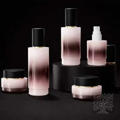Gloss white to ombre black and deep pink gradient cosmetic bottles and matching jars with gold accents, styled in a minimal arrangement on a circular platform.