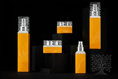 Warm yellow glass skincare bottles and jars with clear caps and silver accents, presented in a structured product layout.