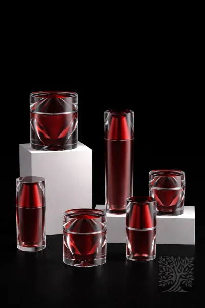 Deep red Leviathan acrylic skincare bottles and cosmetic jars with faceted clear outer shells, arranged on white display blocks.