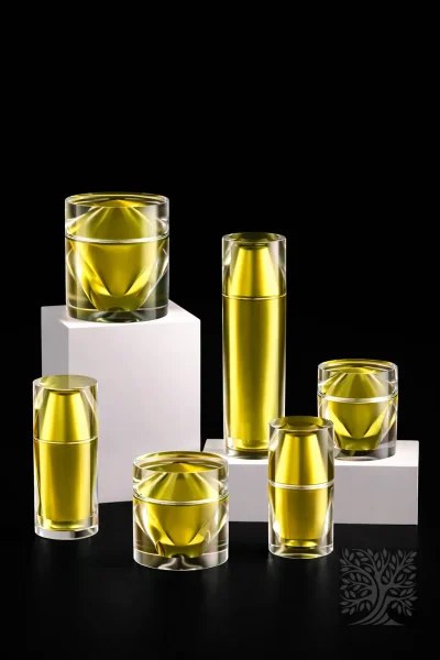 Bright yellow acrylic serum bottles and cosmetic jars with faceted clear shells, presented as a bold luxury packaging set.